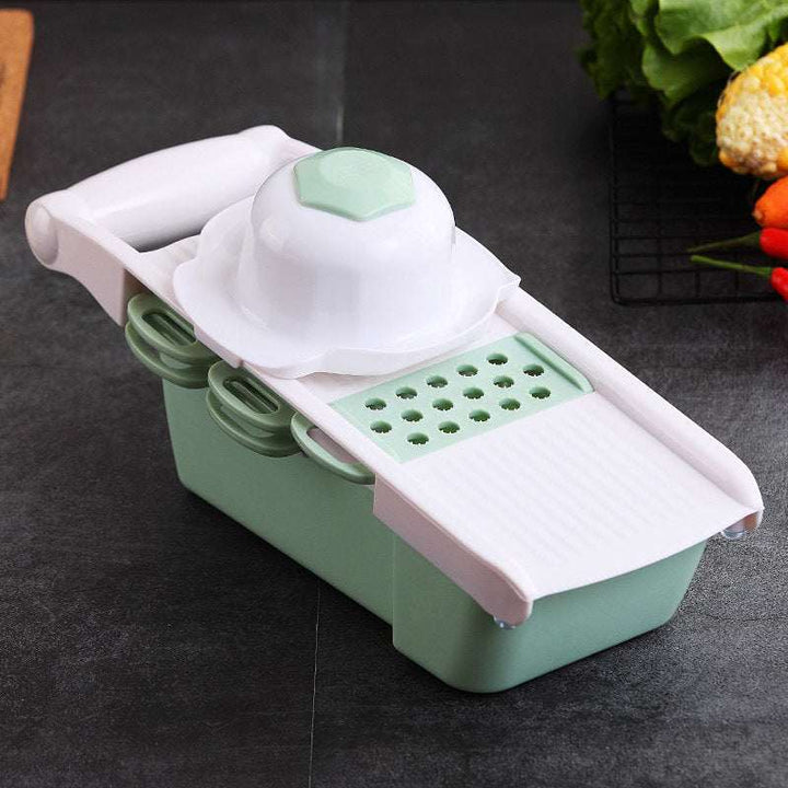Eco-friendly multifunctional kitchen utensil in green, featuring a vegetable cutter and mandoline slicer.