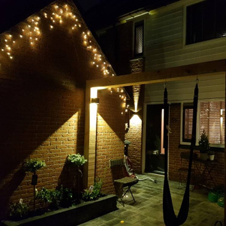Indoor corridor wall lamp illuminating a brick wall with warm light.