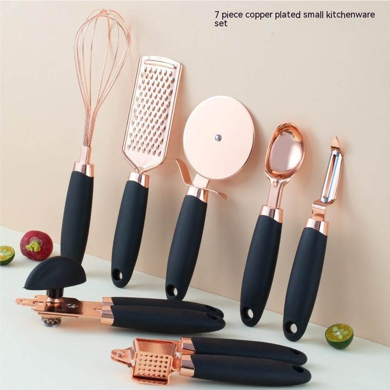 Copper plated kitchen tool set with black handles, featuring a whisk, grater, pizza cutter, spoon, peeler, and more, ideal for household use.