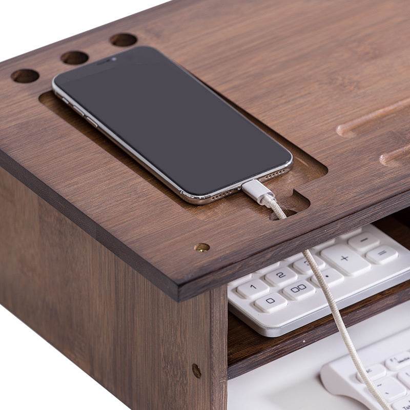Wooden desktop monitor stand with storage, featuring a carved design and phone slot.