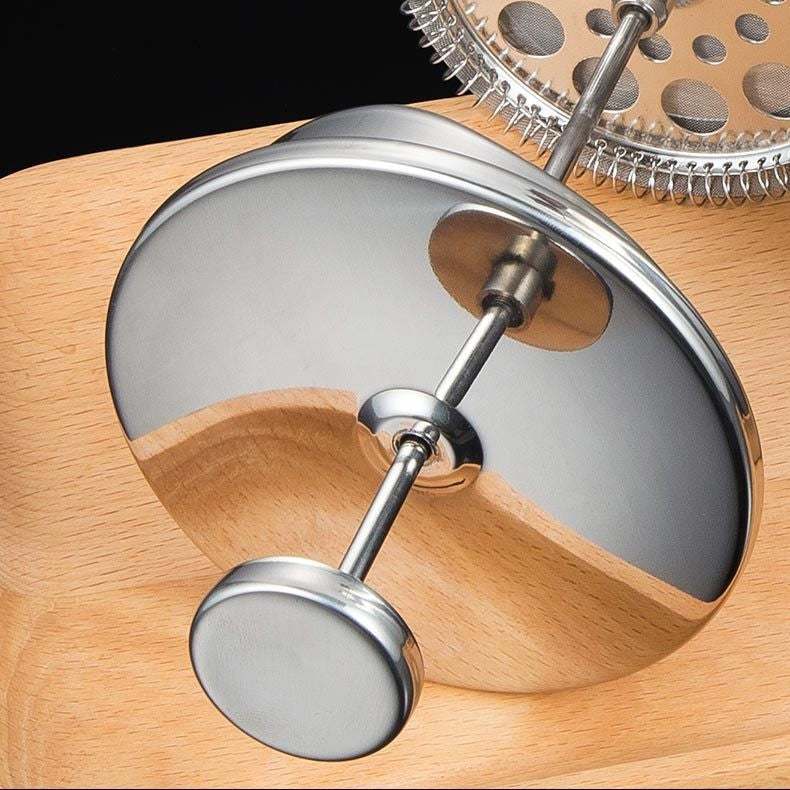 French Press with double-layer stainless steel design on wooden surface.