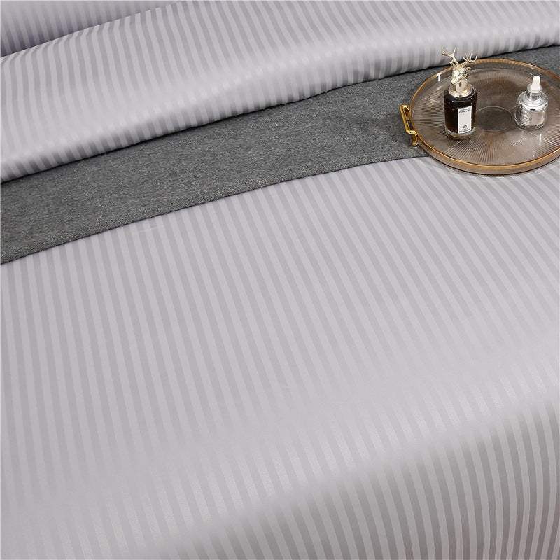 Flower bedding set with geometric pattern on satin fabric, featuring a quilt cover and pillowcases, displayed on a Nordic-style bed.