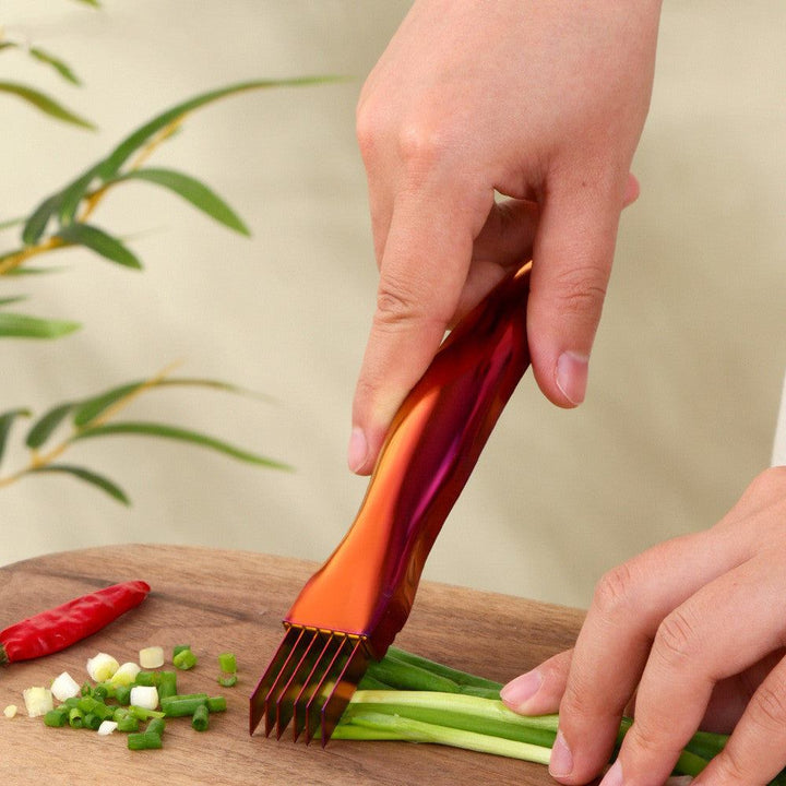 Metallic kitchen onion knife used for slicing green onions.