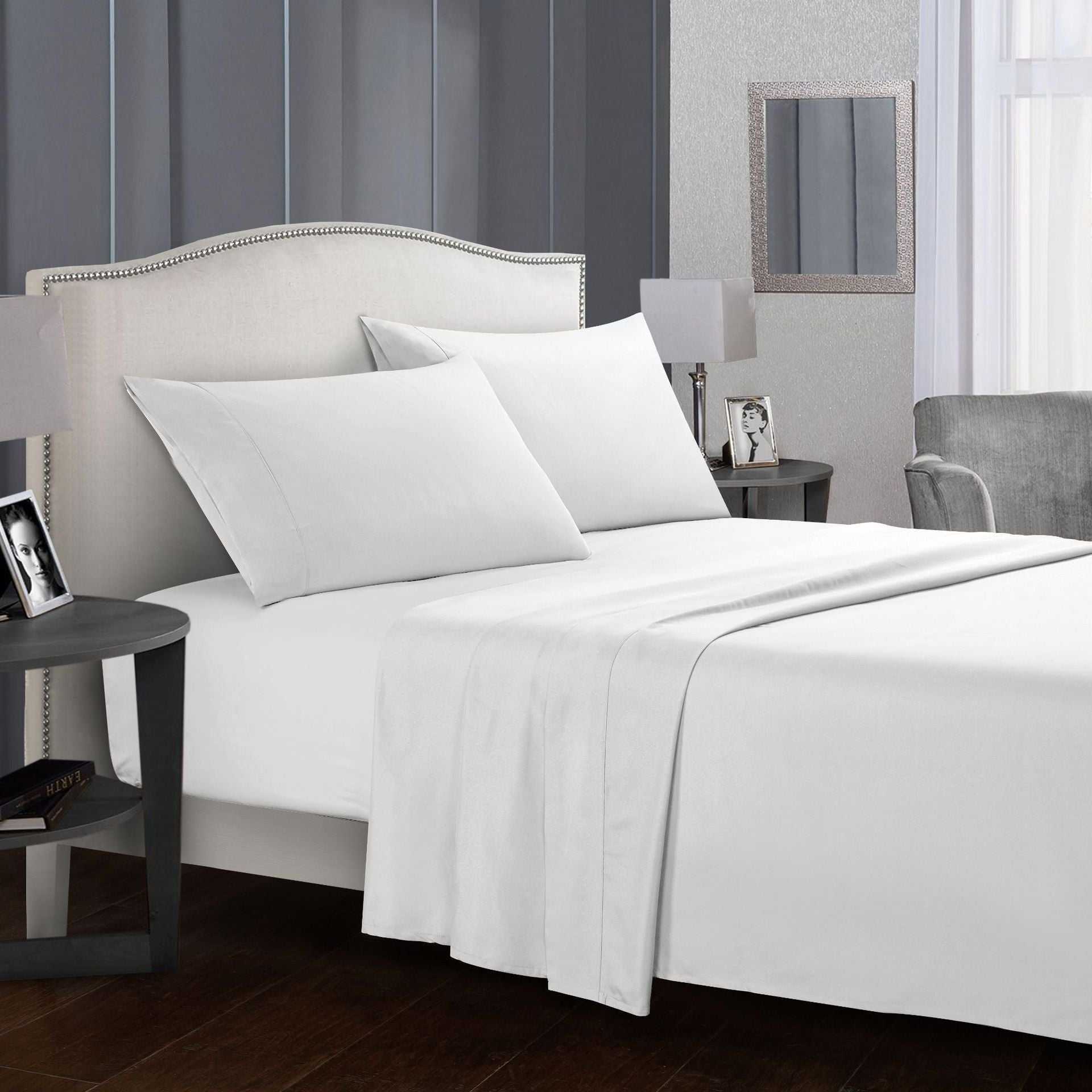Four-piece bed sheet set on a neatly made bed in a modern bedroom setting.