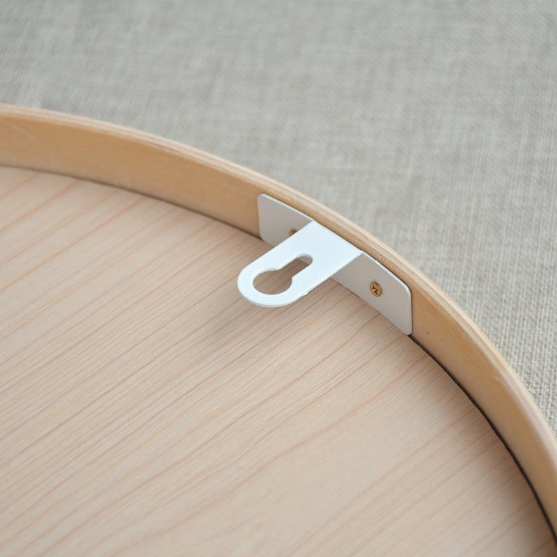 Round solid wood bathroom mirror with natural wood color and simple modern design.