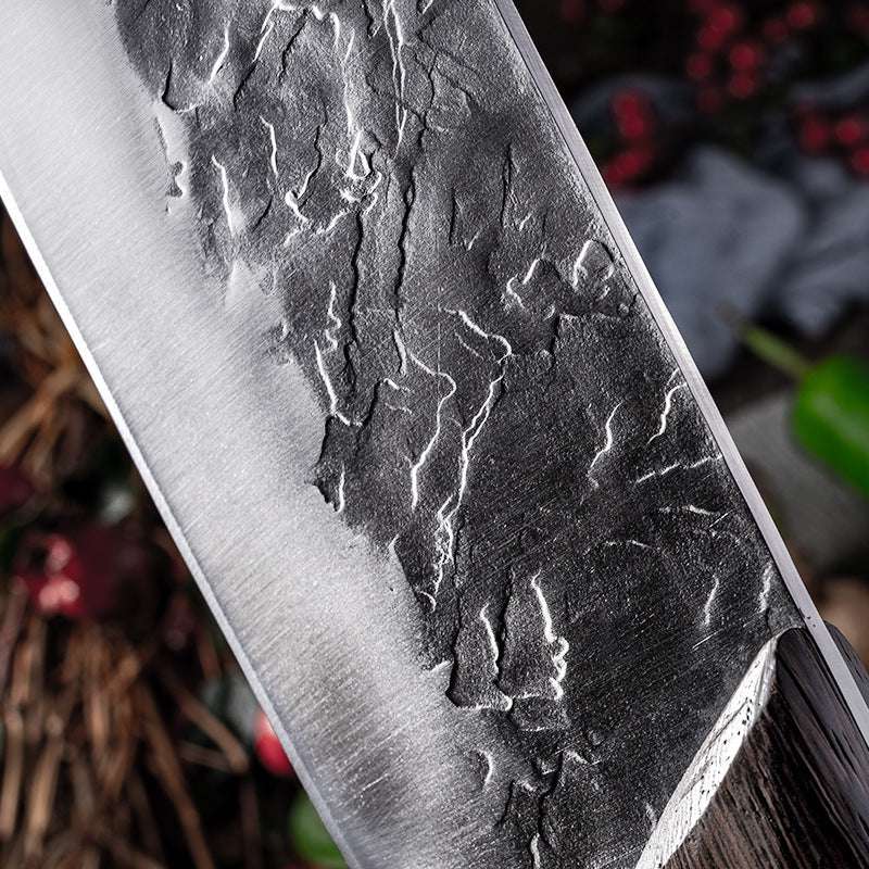 Hand-forged stainless steel knife with textured blade detailing.