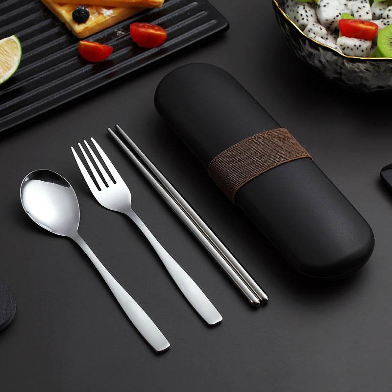 Stainless steel portable cutlery set with spoon, fork, chopsticks, and black carrying case on a table.