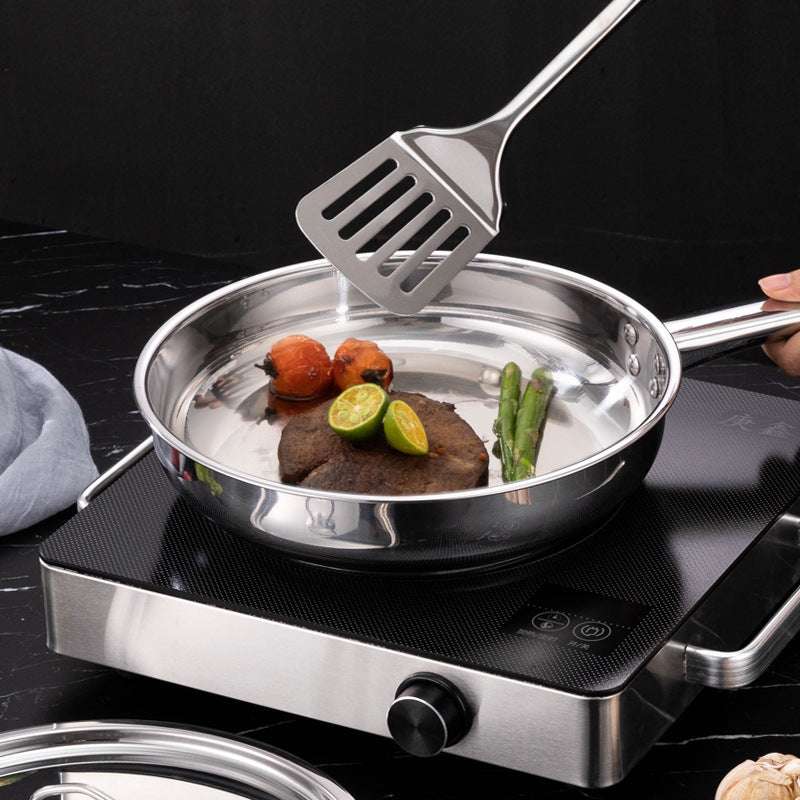 Stainless steel non-stick cookware on stovetop with food.