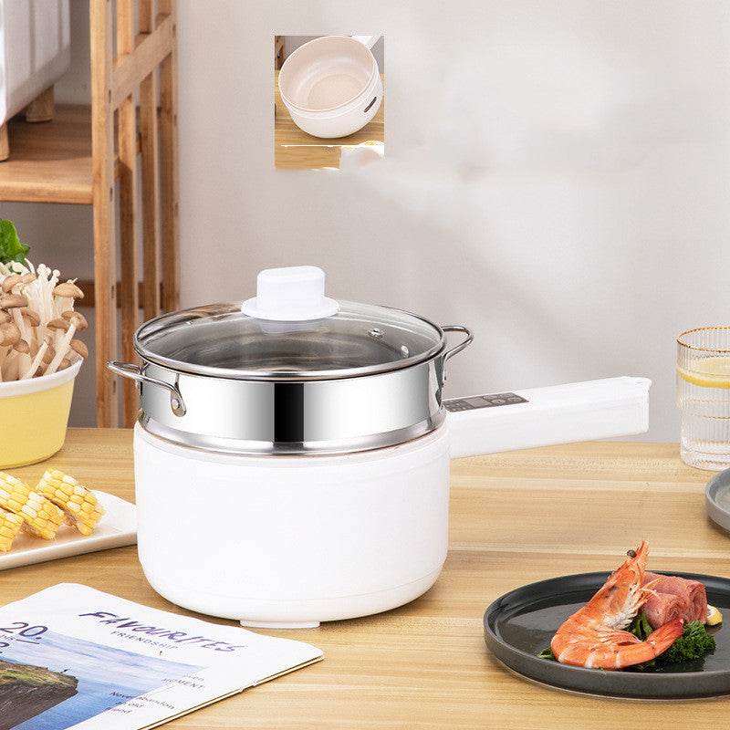 Multifunctional electric cooker with glass lid on a kitchen table, ideal for student dormitories.