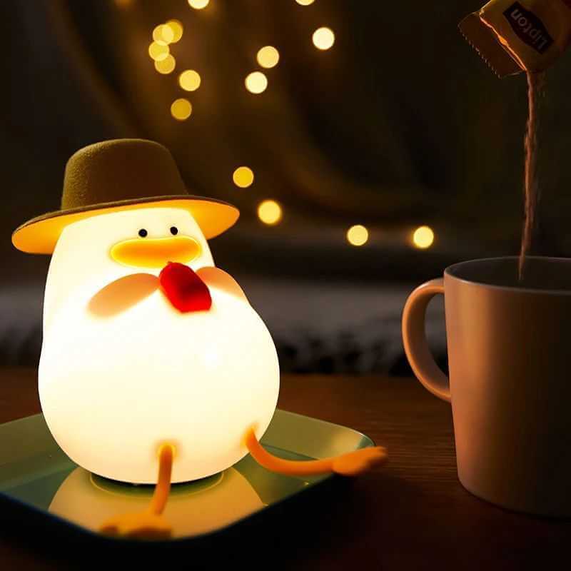 Cute duck-shaped night lamp made of silicone on a table, glowing warmly. 