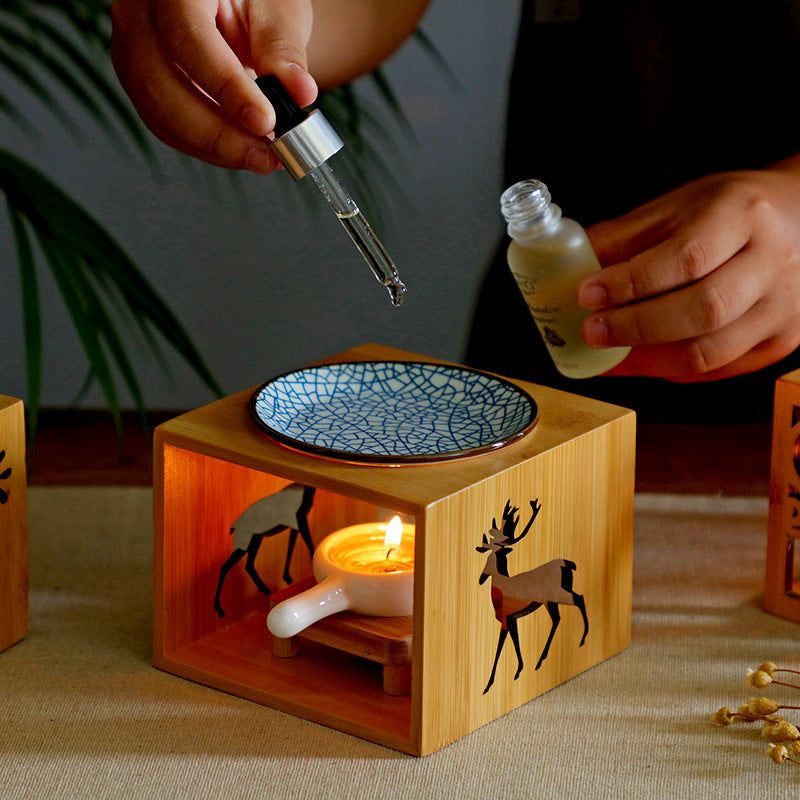 Bamboo candle lamp aromatherapy setup with essential oil dropper.
