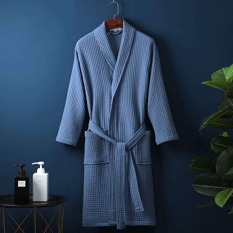 Blue pure cotton waffle bathrobe for couples, hanging on a wall hook.