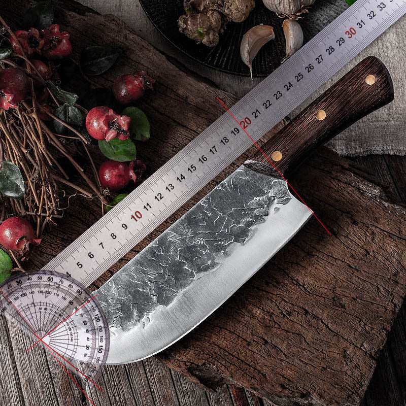 Hand forged stainless steel knife with wooden handle on rustic background.