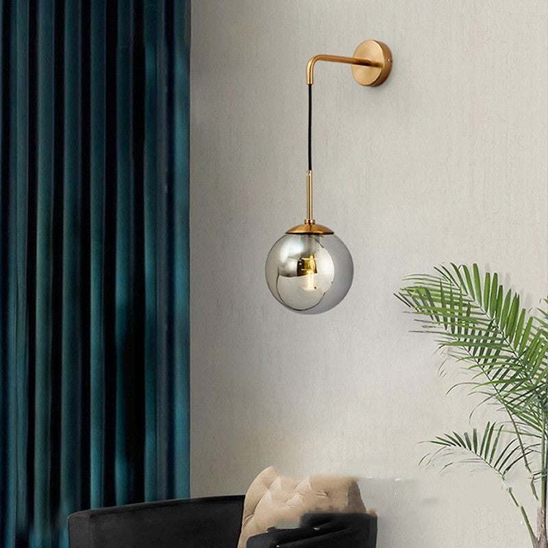 Nordic glass wall lamp with golden light body in living room setting.