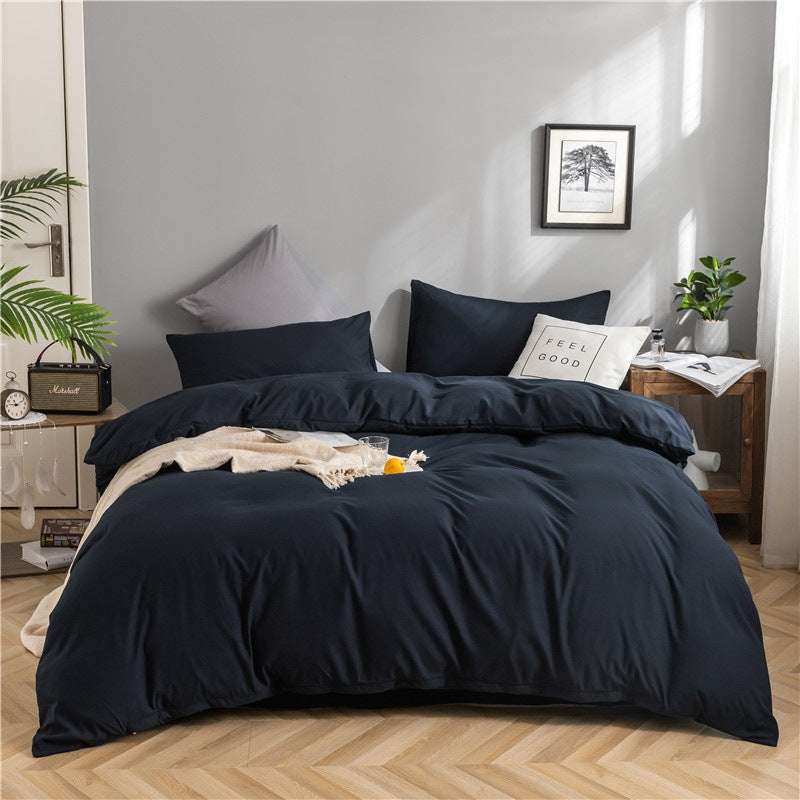 Modern minimalist dark-colored four-piece bedding set in a bedroom with geometric pattern.