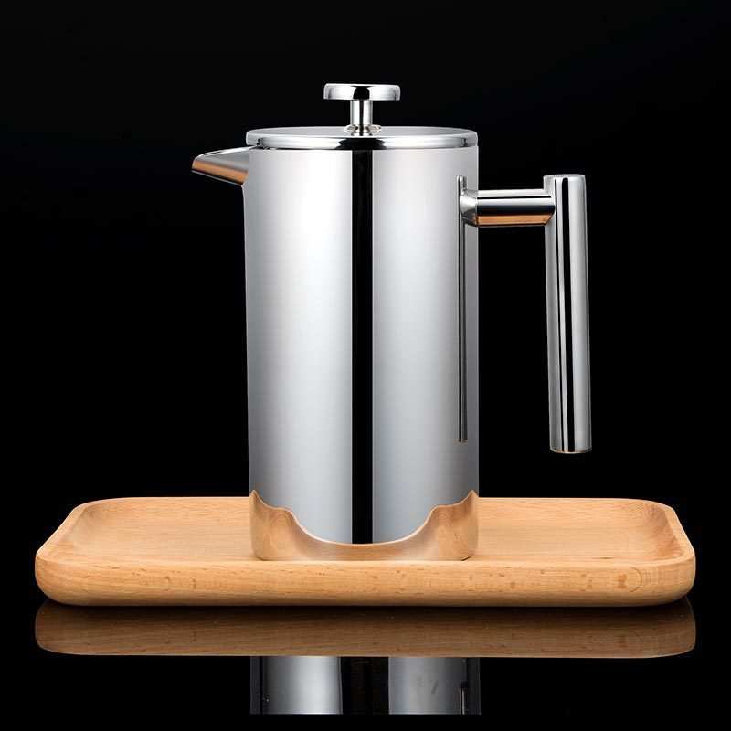 Double-layer stainless steel French press on wooden tray.
