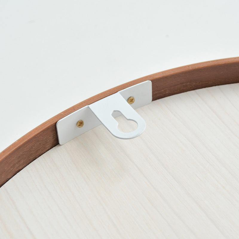 Round wooden bathroom mirror with walnut finish and hanging hook, simple modern design.