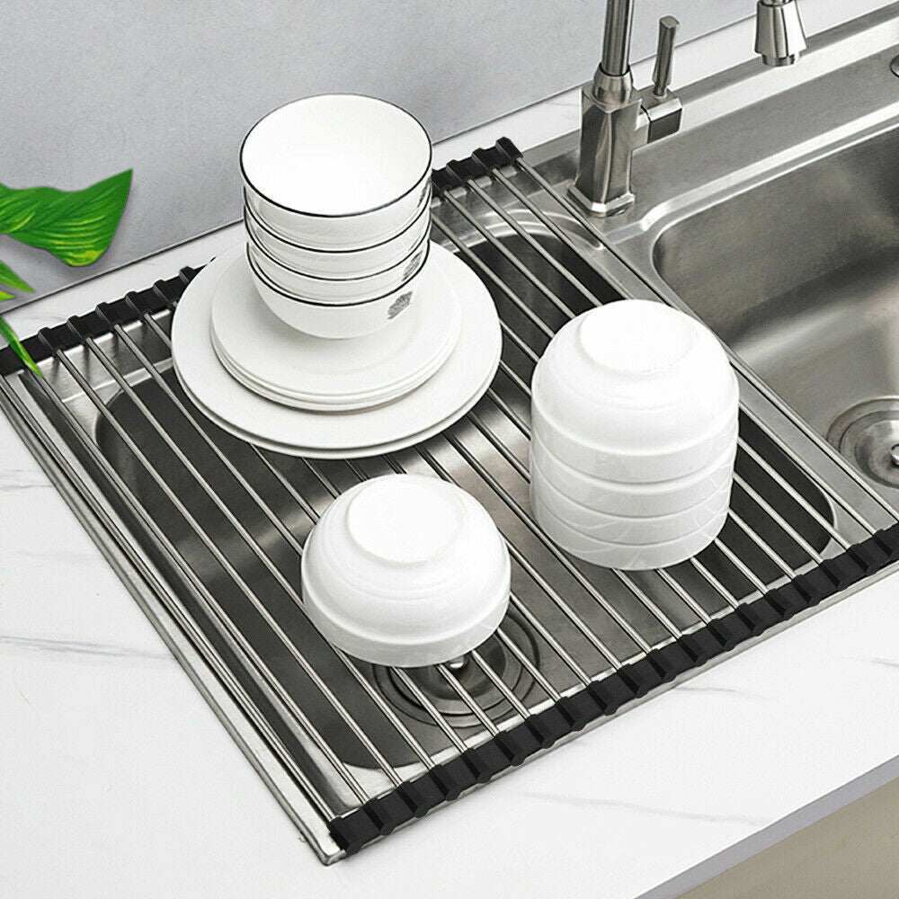 Kitchen stainless steel sink drain rack with dishes and bowls, rectangular design, black and silver color.