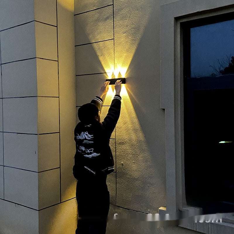 Solar lamp outdoor installed on a courtyard wall, providing super bright warm lighting.