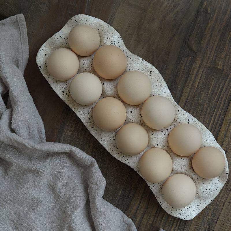 Nordic style resin egg storage box with 12 cells on a wooden surface.