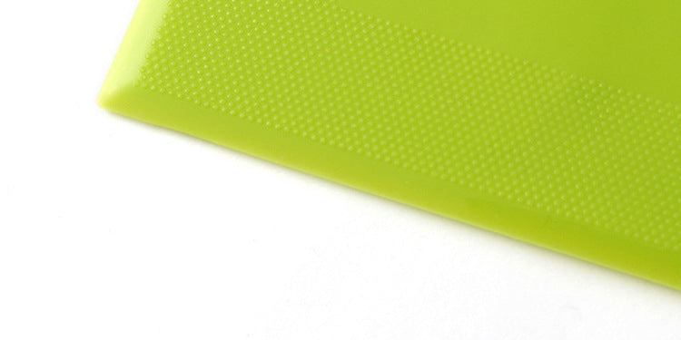 Green plastic kitchen flour cutting scraper corner detail.