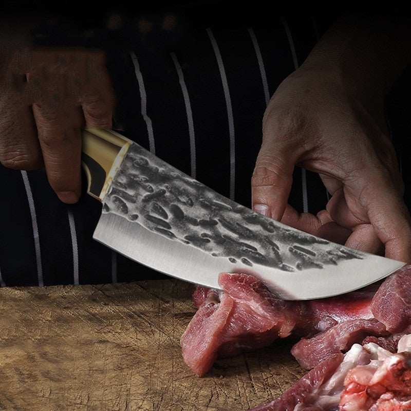 Stainless steel meat cleaver slicing through meat on a wooden board.