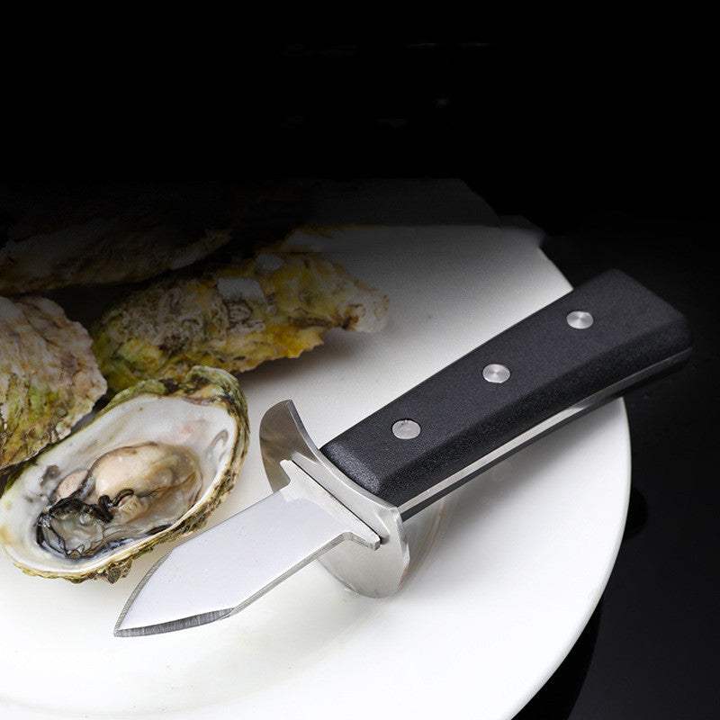 Stainless steel oyster shell knife with red wooden handle on a plate with opened oysters.